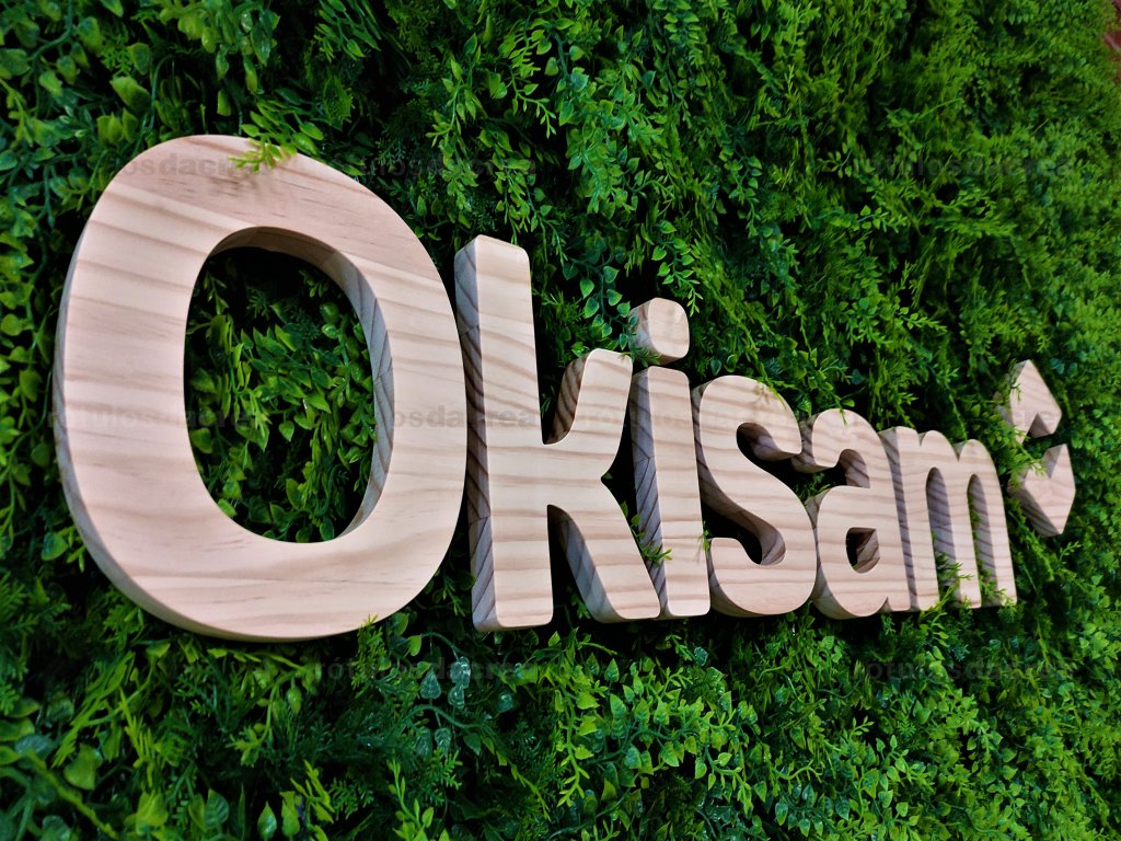 Letras corpóreas de madera sobre jardín vertical