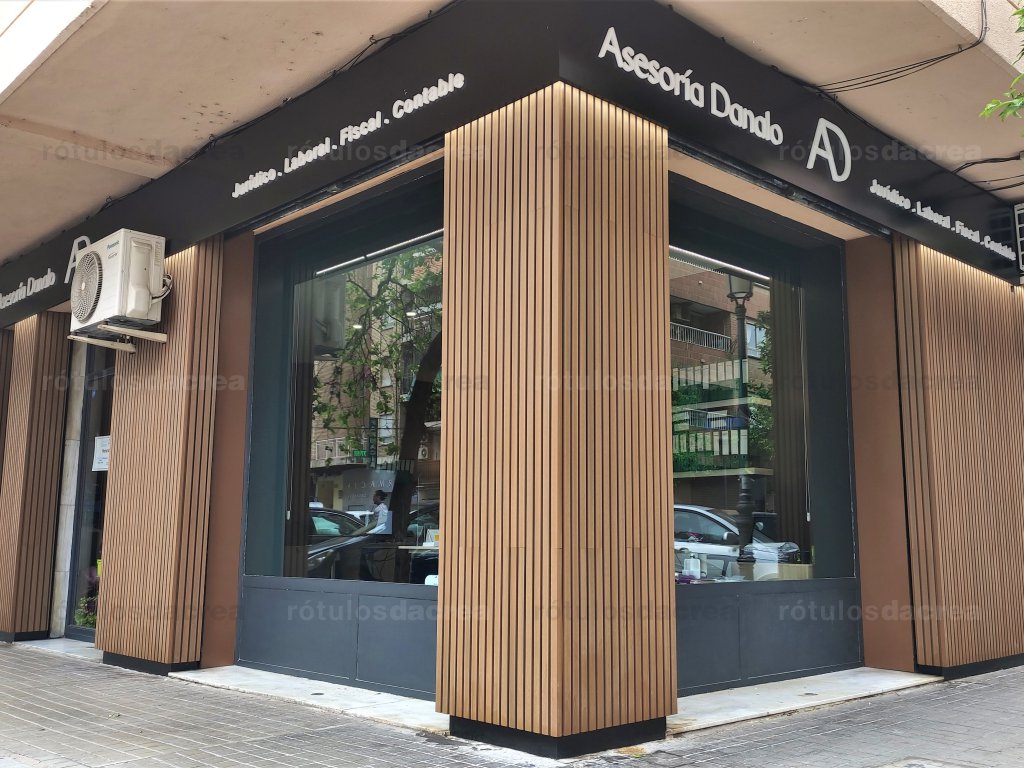 Revestimiento con listones de madera iluminado por arriba desde bandejas