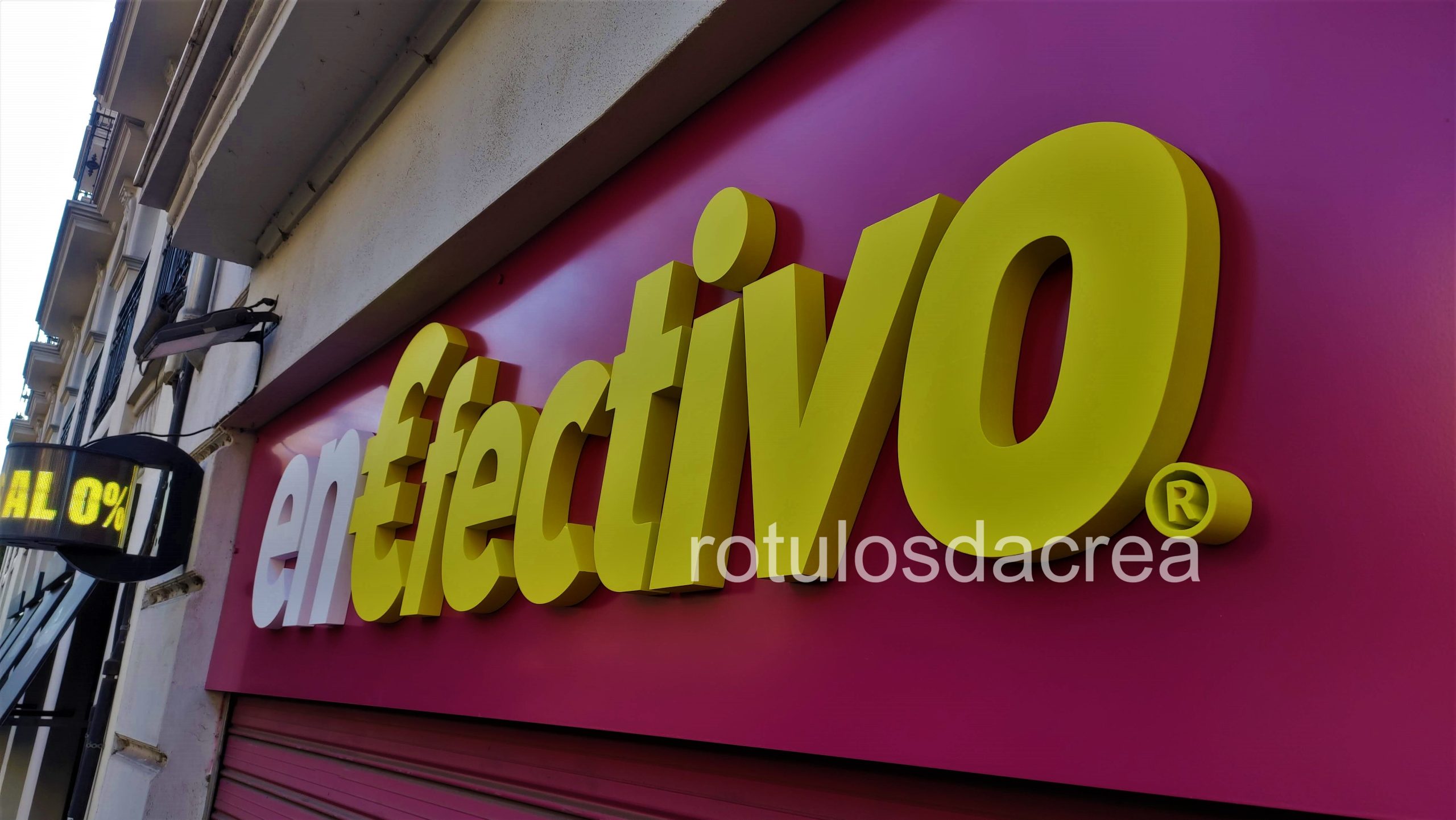 Letras corpóreas en corcho para EnEfectivo en Valencia, rótulo exterior amarillo sobre fondo magenta