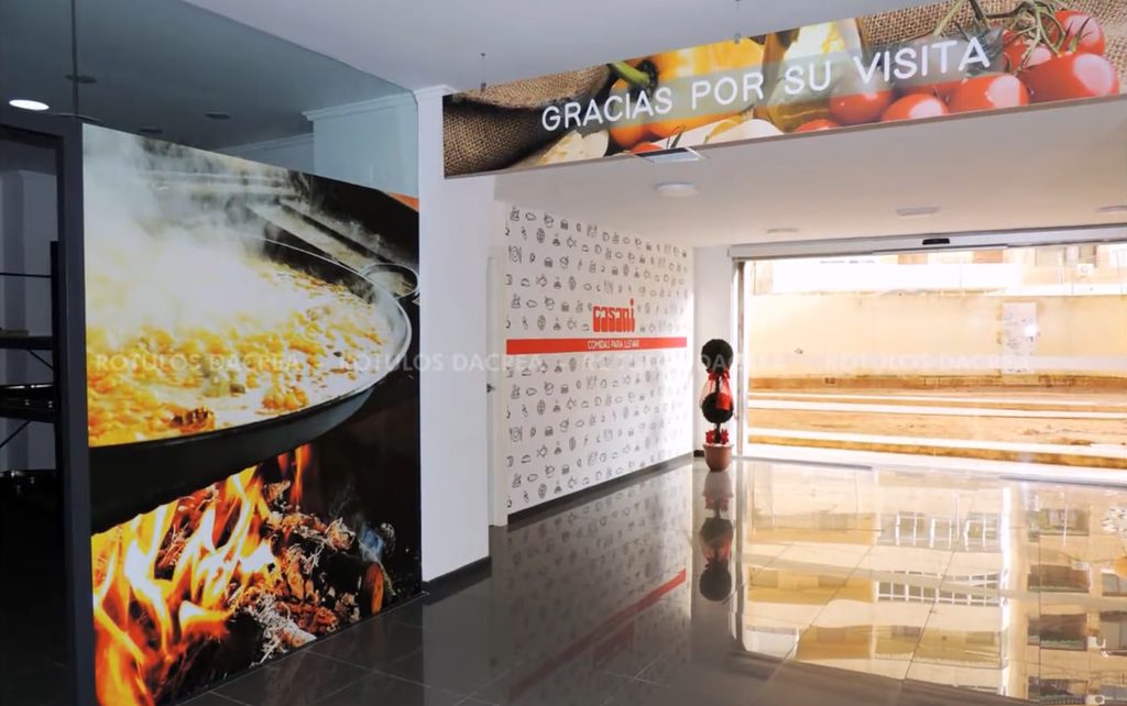Fotomural impreso de una paella al fuego y friso superior con el mensaje de despedida en Casaní