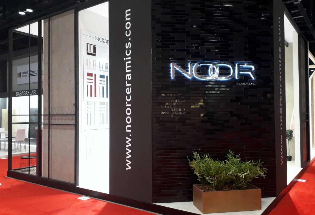 Letras corpóreas retroiluminadas con acabado espejo en el stand de Noor Ceramics en una feria
