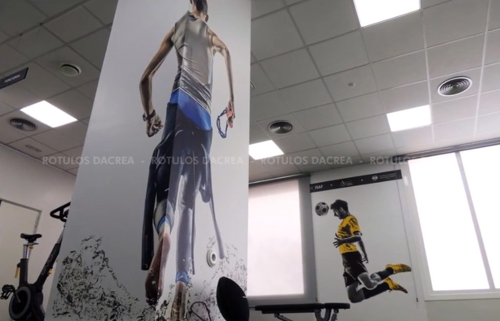 Mural de una corredora sobre columna en la sala de entrenamiento del Instituto ISAF