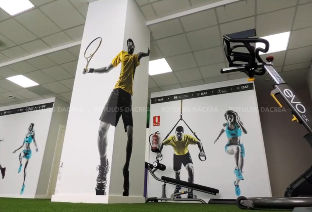 Mural de un tenista a altura completa sobre una columna de la sala del Instituto ISAF