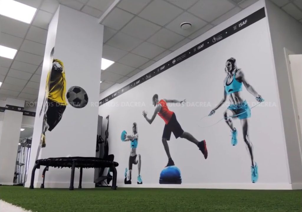 Murales de deportistas sobre pared y columna en la sala de entrenamiento del Instituto ISAF