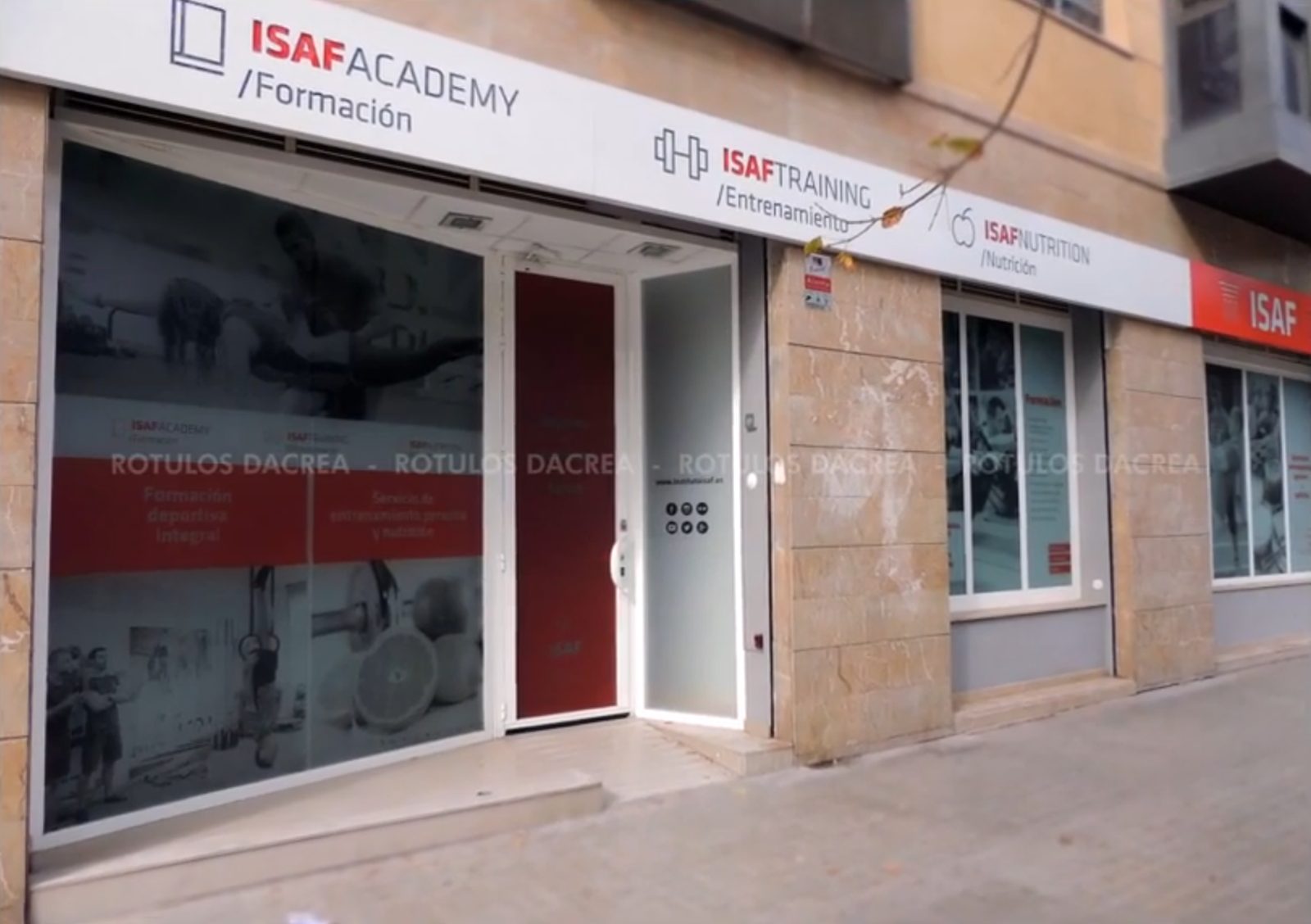 Fachada del Instituto ISAF en Valencia con la banda de las tres líneas y el rótulo rojo de la marca