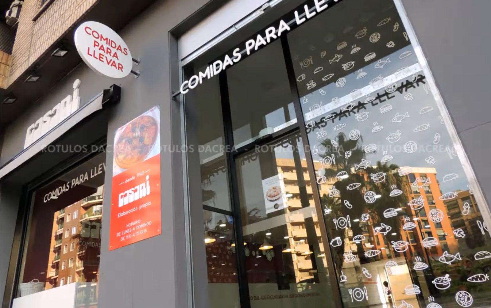 Fachada de Casaní en Valencia con banderola circular, letras corpóreas y placa informativa