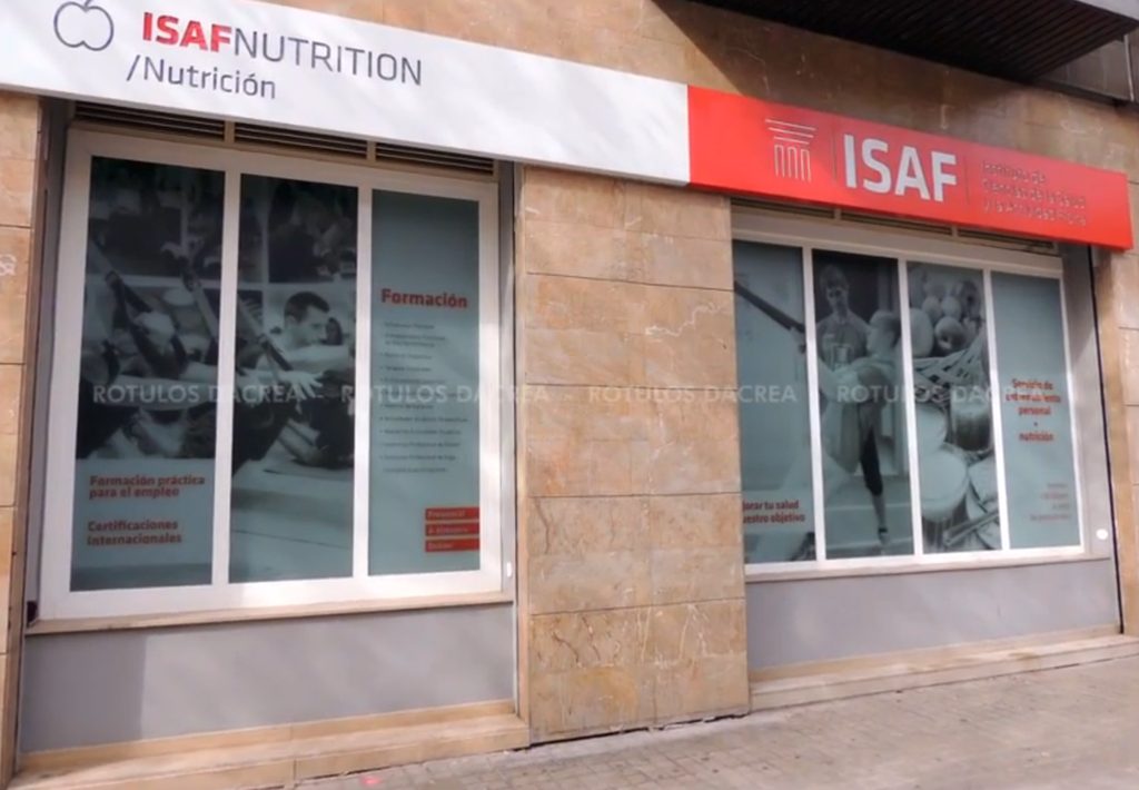 Rótulo corporativo rojo del Instituto ISAF junto a los escaparates rotulados con vinilo impreso