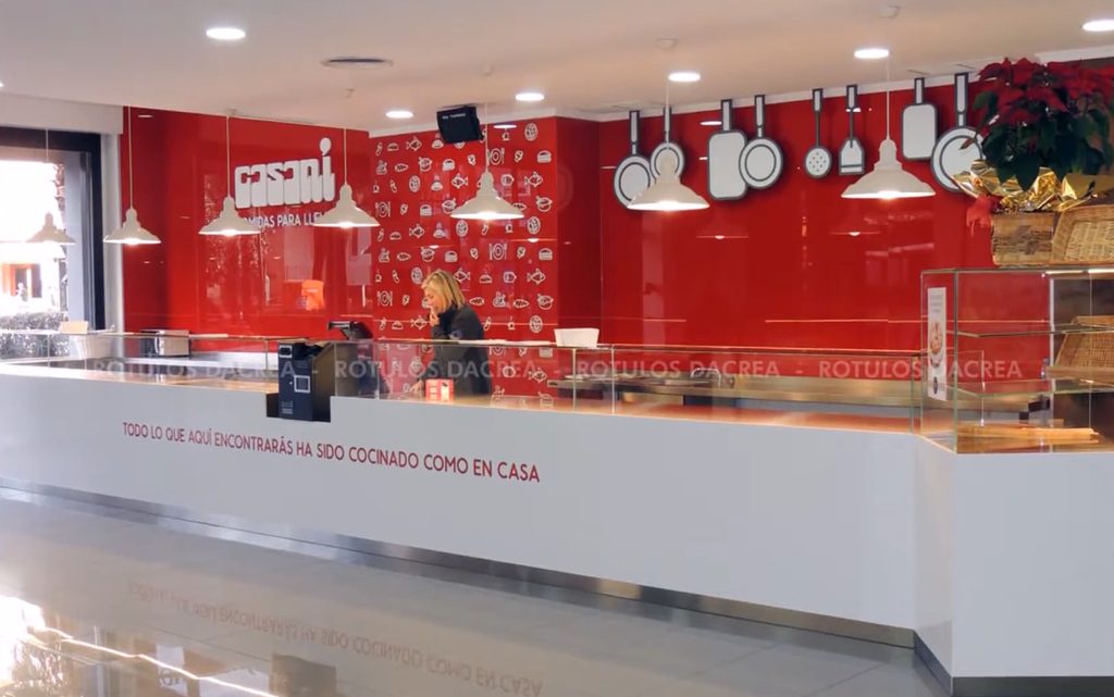 Frente del mostrador de Casaní con el mensaje de la casa en vinilo de corte rojo